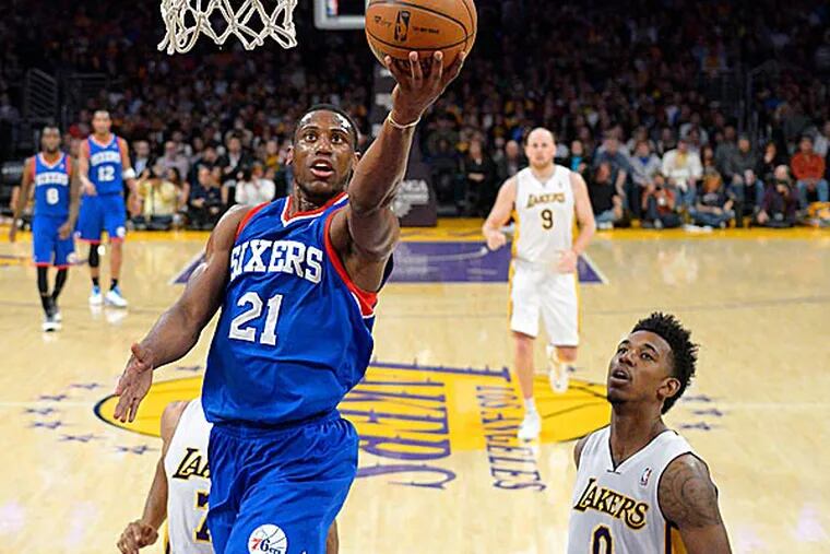 76ers forward Thaddeus Young puts up a shot as Lakers forward Nick Young defends. (Mark J. Terrill/AP)