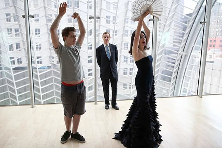 Catherine Clifton receives dance tips from David Rubio (left), a student at the High School for Creative and Performing Arts as her husband, Anthony, watches on the garden roof at the Kimmel Center. The Cliftons created an award for young artists; Rubio is a recipient. (David Maialetti / Staff Photographer)