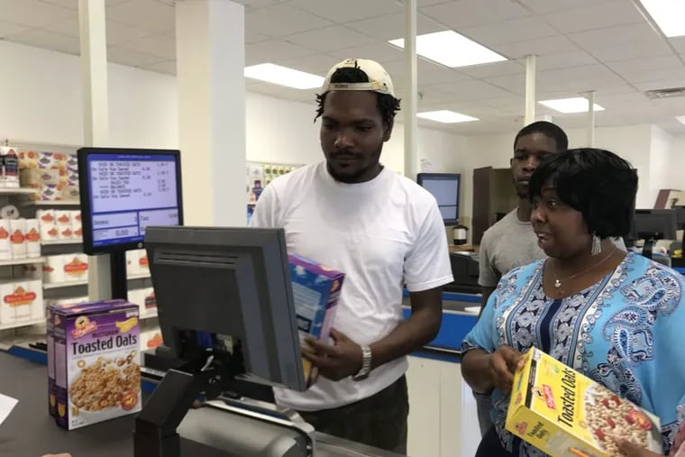 Keith Choice, 27, gets tips on how to work the register from instructor Monique Oakman as fellow student Rahiem Paige watches.
