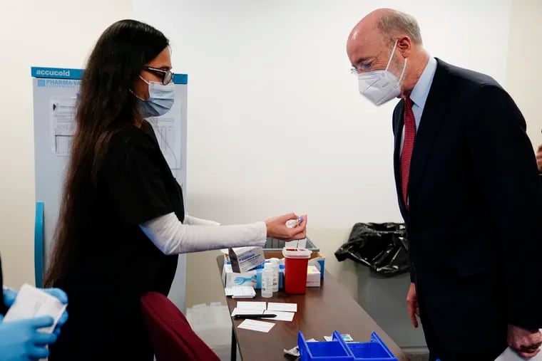Gov. Tom Wolf looks at a vial of the Johnson & Johnson COVID-19 vaccine at a vaccination site set up setup for teachers and school staff at the Berks County Intermediate Unit in Reading on Monday, March 15.