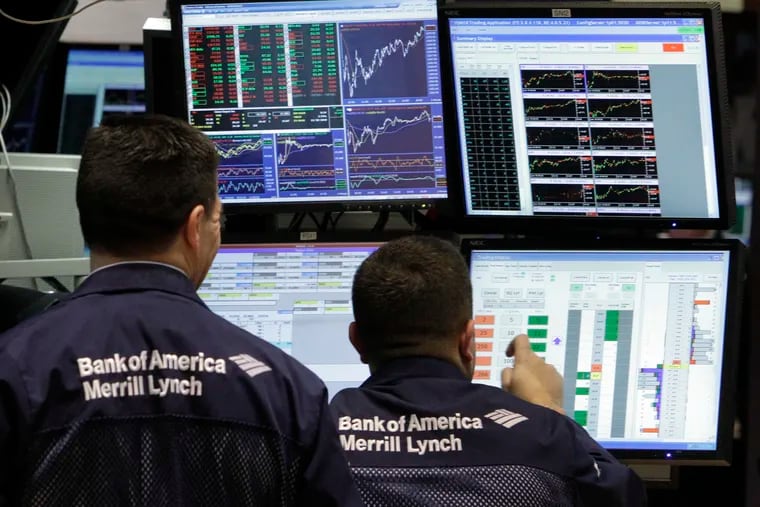 A pair of Bank of America-Merrill Lynch specialists work at their post on the floor of the New York Stock Exchange in 2011.