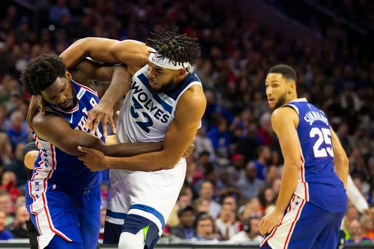 Joel Embiid (left) fights with the Timberwolves' Karl-Anthony Towns (32) as Ben Simmons (25) looks on in the third quarter on Oct. 30.