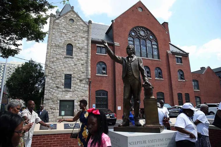 Visitors take photos of the Richard Allen statue during a stop at Mother Bethel African Methodist Episcopal Church in Philadelphia.