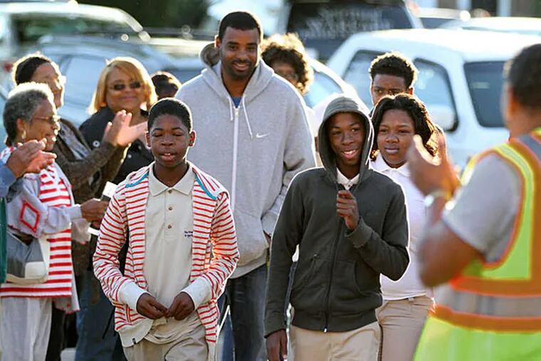 Students are welcomed as they walk into Martin Luther King High School in Germantown yesterday. Much-anticipated tensions between students emigrating from Germantown High School and Bok Technical School were nonexistent, according to staff at King. (Michael Bryant/Staff)