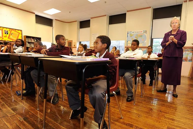 In this file photo from 2018, sixth-grade students sit in new desks as Sister Nancy Fitzgerald, principal of St. Martin de Porres Catholic School, talks to them.