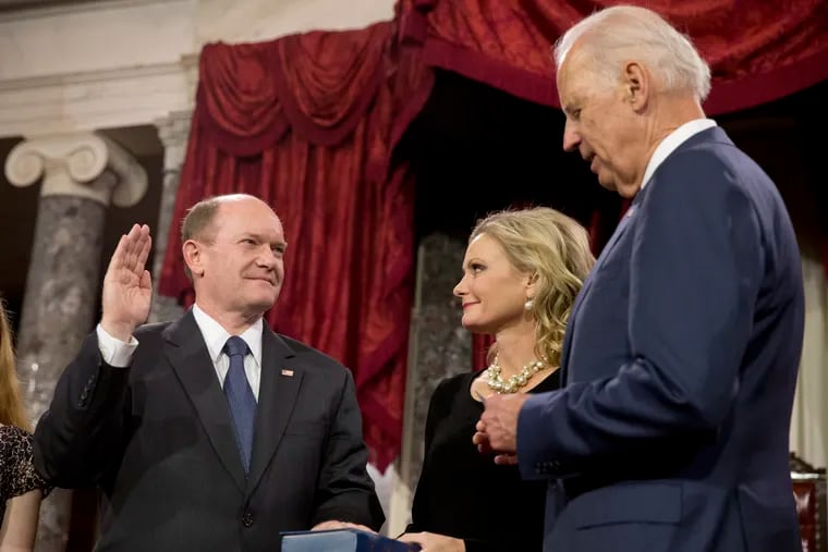 In this Jan. 6, 2015, file photo, Vice President Joe Biden administers the Senate oath to Sen. Chris Coons, D-Del., as Coons' wife, Annie Coons, watches during a ceremonial re-enactment swearing-in, in the Old Senate Chamber on Capitol Hill in Washington.