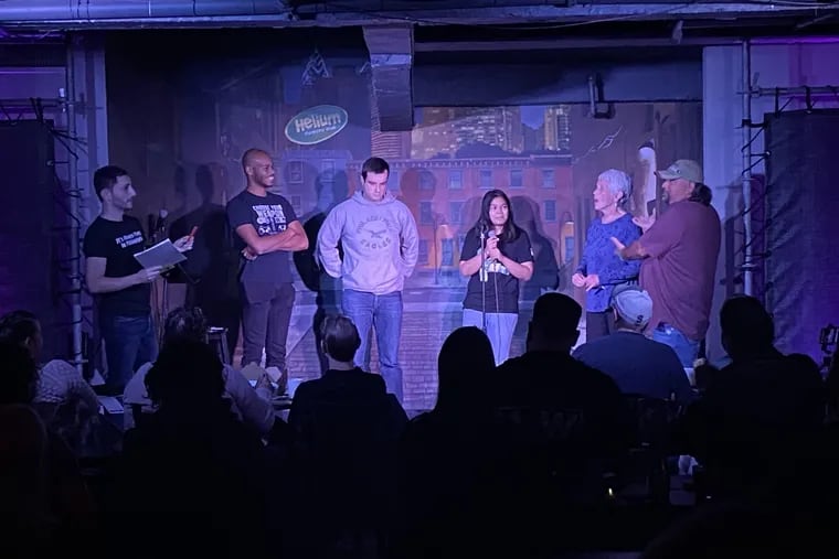 Aaron Schwartzbaum (left), founder of "It's Always Punny in Philadelphia," leads contestants in the "Pundemonium" portion of his pun-off Saturday at Helium Comedy Club.