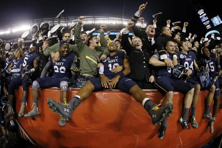 Navy quarterback Keenan Reynolds (19) celebrates with fellow Navy Midshipmen after an NCAA college football game against Army, Saturday, Dec. 12, 2015, in Philadelphia. Navy won 21-17.
