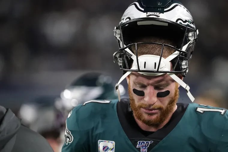 Eagles quarterback Carson Wentz walks along the bench in the 4th quarter in the Philadelphia Eagles fall 37-10 to the Dallas Cowboys at AT&T Stadium in Arlington, TX on October 20 2019.