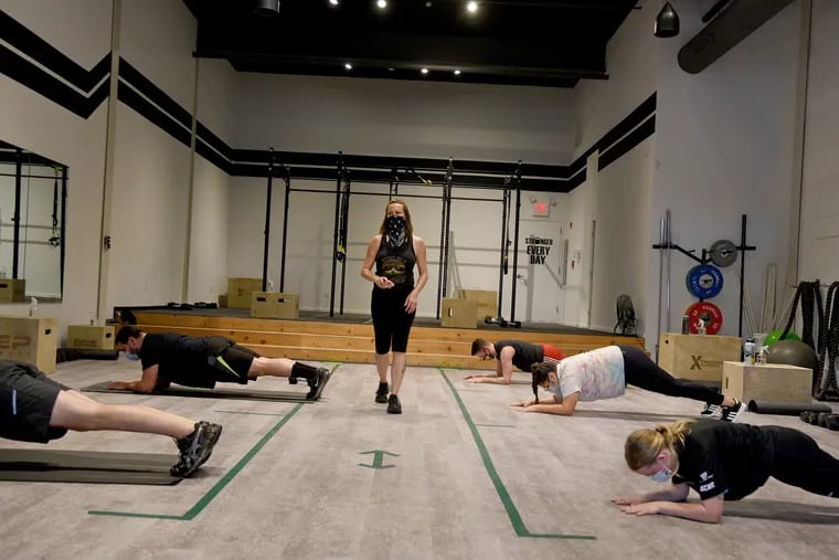 Trainer Kati Kill conducts a class with five members at Revolution Fitness Factory. Gyms in the city were allowed to reopen this week but had to follow stricter rules than fitness centers in the rest of the state.