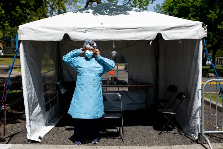 Tijuana Johnson, a licensed practical nurse at Cooper University Health Care, gets ready to do walk-up tests for people who have potential symptoms of the coronavirus at a testing site in Dudley Grange Park in Camden on Tuesday.