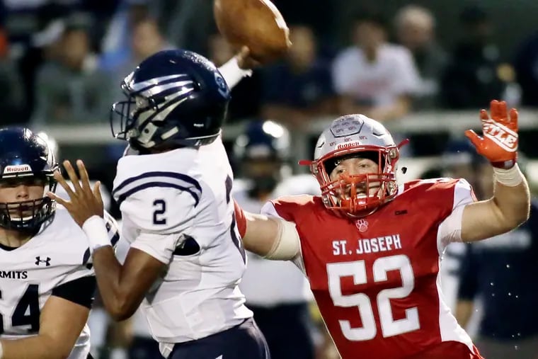 St. Augustine's Chris Allen (No. 2), here passing under pressure from St. Joseph's Brad Lomax (No. 52), will lead the Hermits in Friday night's showdown with Holy Spirit.