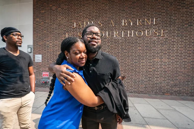 Anthony “Ant” Smith, back center, receives a hug from friend Alyssa King, among the friends and family who arrived at the federal courthouse in Center City to support him as he pleaded guilty Tuesday to obstructing police during civil disorder in 2020.
