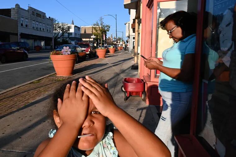 August 13, 2021: Ophelia Santo and Nicole Nunez, 4, in downtown Coatesville. Nicole’s mother operates a hair salon on Lincoln Avenue, the main street through town. Santo is a family friend.