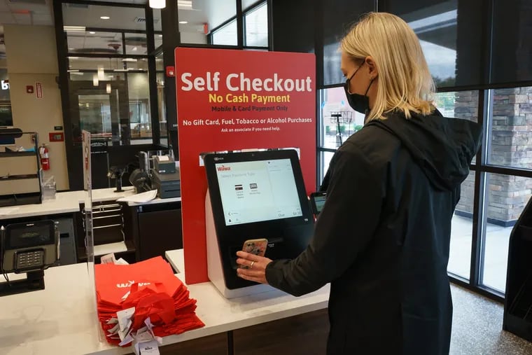 Alyson Mucha, Public Relations Coordinator, demonstrates the self-checkout at the new Wawa on 9101 Frankford Ave. in Philadelphia. The store is opening next week.