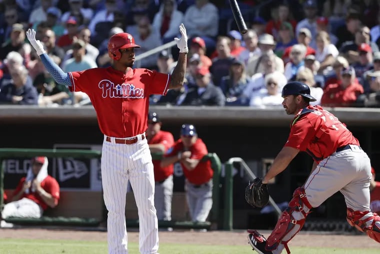 Phillies Nick Williams raises his arms tossing his bat after striking out swinging to end the fourth-inning against the Red Sox during spring training.