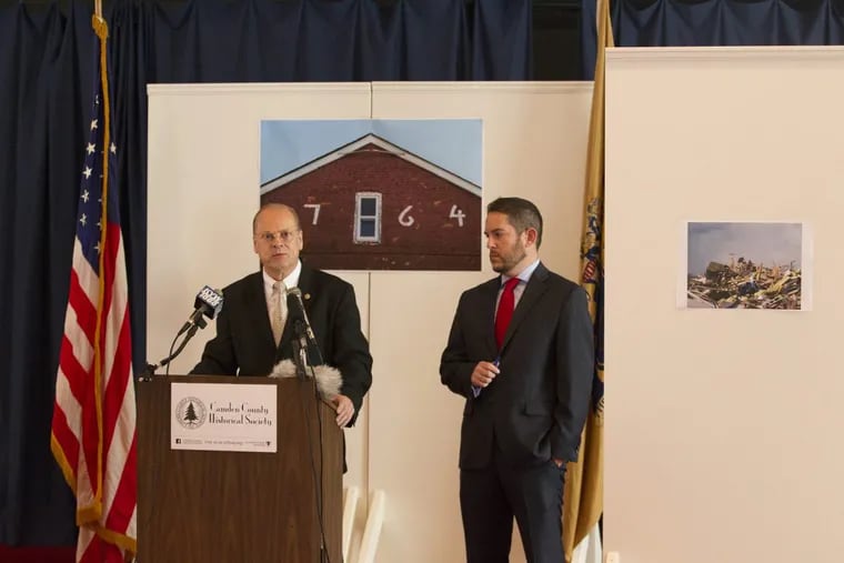 Chris Perks (left), president of the Camden County Historical Society, and attorney Matthew Litt  announce a suit against the New Jersey Department of Transportation. The backdrop shows images of the 1764 Hugg-Harrison-Glover House before and after it was leveled.