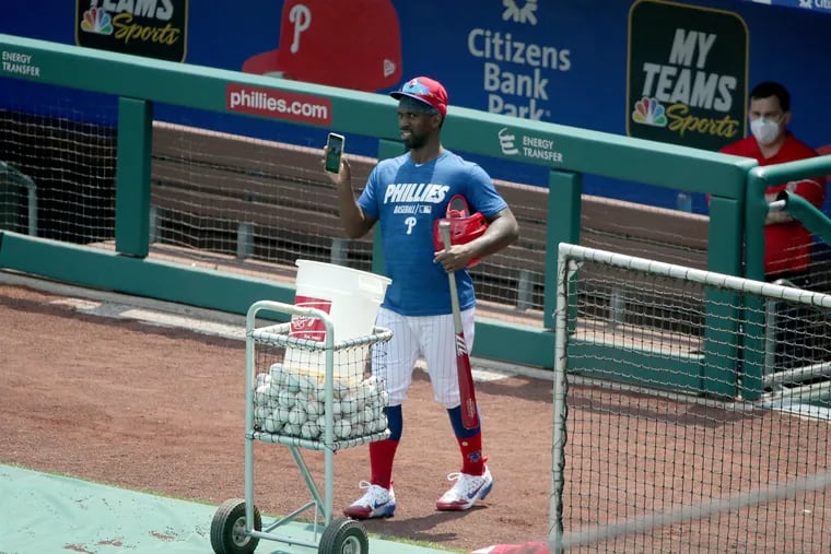 Outfielder Andrew McCutchen captures the scene with his phone as he prepares to take batting practice during the Phillies workout at Citizens Bank Park on Monday.