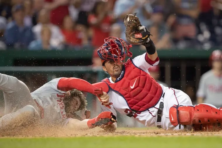 Nationals catcher Kurt Suzuki raises his glove after tagging out the Phillies' Bryce Harper at the plate during the fourth inning Thursday.