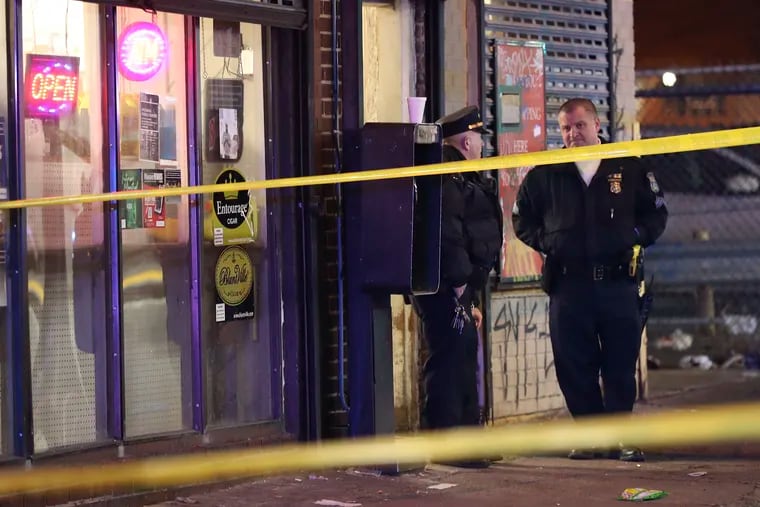 Philadelphia Police officers stand outside the Neighborhood Market along the 1500 block of Arrott Street after several  people were shot at the Frankford neighborhood market on Jan. 23. The department recently launched a new unit of detectives assigned exclusively to nonfatal shootings.
