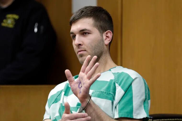 FILE - In this March 18, 2019, file photo, Anthony Comello displays writing on his hand that includes pro-Donald Trump slogans during his extradition hearing in Toms River, N.J. Comello is accused of killing the reputed boss of New York’s Gambino crime family, Francesco “Franky Boy” Cali, and for that, Comello may have more than legal problems to worry about — namely, whether the Mafia is going to get its hands on him. (AP Photo/Seth Wenig, File)