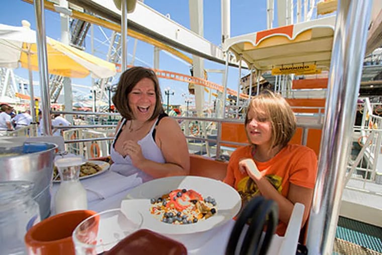 Nanny Dawn Andersen, left, and her charge, Corra Nocella, 10, both of Hamden, N.Y., prepare for their breakfast in the sky as they sit in their gondola on Morey's ferris wheel in Wildwood. (Ed Hille / Staff Photographer)