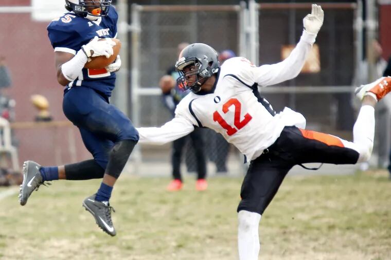West Philadelphia's Damiyr Martinez makes a catch over the middle while defended by Overbrook's Clifford Brinkley during the fourth quarter of a Thanksgiving Day football game Thursday, Nov. 24, 2016 at 48th and Spruce in West Philly. Overbrook went on to win, 22-20, in overtime. LOU RABITO / Staff