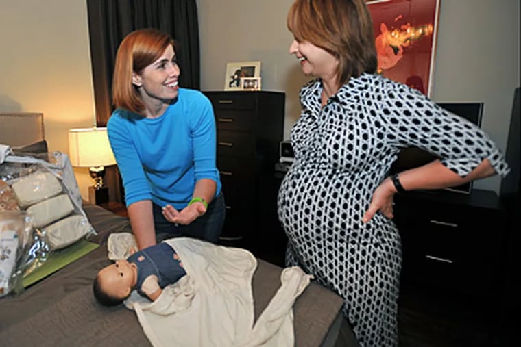Baby planner Shannon Choe makes a house call to expectant mother Michele Andelbradt in her Villanova home. Choe demonstrates the proper way to swaddle a baby. (Sharon Gekoski-Kimmel / Staff)