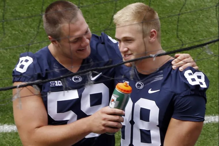 Penn State offensive tackle Andrew Nelson (left) uses a water bottle as a prop while pretending to interview tight end Mike Gesicki (88) during the Penn State’s media day.