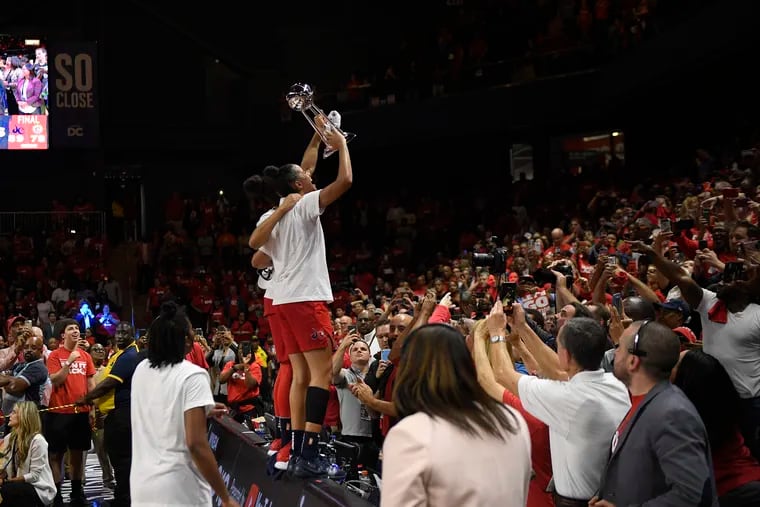 Broomall native and St. Joe's product Natasha Cloud raises the trophy to the crowd after helping the Washington Mystics win their first WNBA championship.
