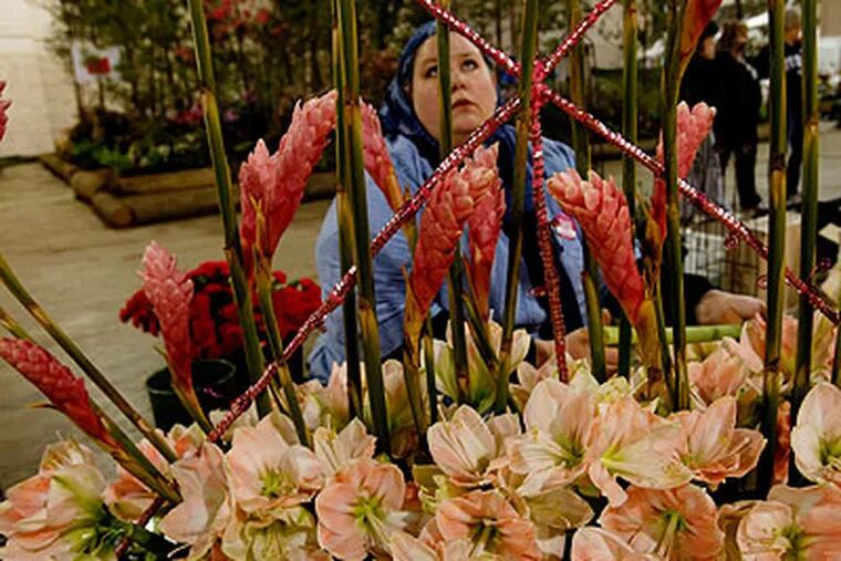 Florist Jennifer Abdelmottaleb works on a dream catcher Friday for the Flower Show exhibit, "Reves de Fleurs," earlier this month. (Michael S. Wirtz / Staff Photographer)