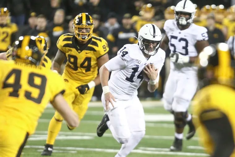 Penn State quarterback Sean Clifford (14) scrambles on a keeper in the second half in front of Iowa linebacker Nick Niemann (49) and defensive end A.J. Epenesa (94) on Saturday, Oct. 12, 2019, at Kinnick Stadium in Iowa City, Iowa. The visiting Nittany Lions won, 17-12. (Matthew Holst/Getty Images/TNS)