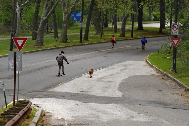 Walkers, skateboarders, and bikers pass near the Strawberry Mansion Bridge on Martin Luther King Drive, which has been closed to vehicular traffic since March 20, in the interest of facilitating social distancing during the coronavirus pandemic.