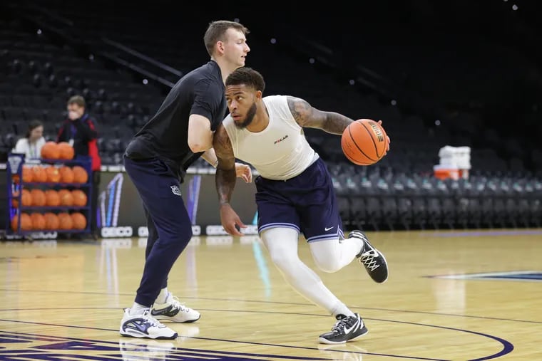 Justin Moore (right) of Villanova runs through drills with graduate assistant Kevin Voigt in December.