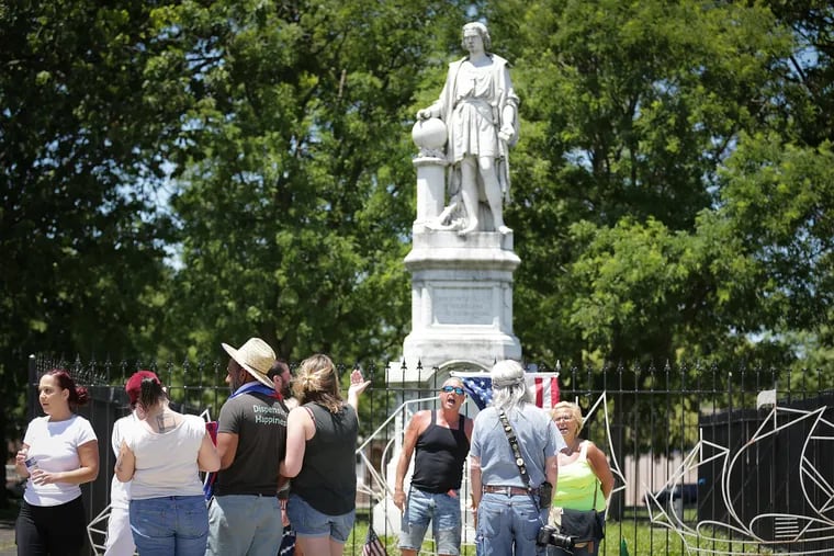 A group of pro-Columbus supporters (background) and anti-Columbus supporters (foreground) gather in front of the Christopher Columbus statue in Marconi Plaza on Sunday.