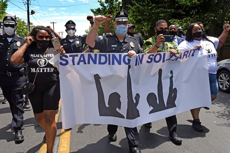 In this Saturday, May 30, 2020, photo, Camden County Metro Police Chief Joe Wysocki raises a fist while marching with Camden residents and activists in Camden, N.J., to protest the death of George Floyd in Minneapolis.