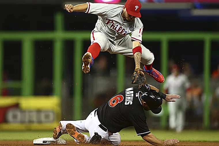 Phillies shortstop Freddy Galvis leaps over the Marlins' Jeff Mathis. (J Pat Carter/AP)
