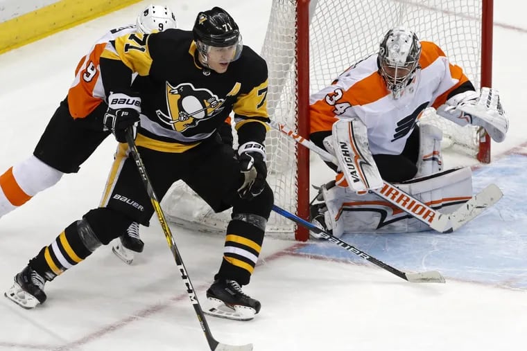 Pittsburgh center Evgeni Malkin (71) loses control of the puck in front of  Flyers goaltender Petr Mrazek with Ivan Provorov (9) defending during overtime of the March 25 game. The teams will open their playoff series Wednesday in Pittsburgh.