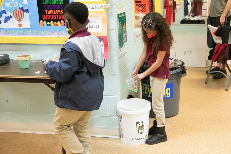 Skylar Sanchez, 7, dumps food scraps in the compost bucket at the Simpson Recreation Center in Frankford on Wednesday.