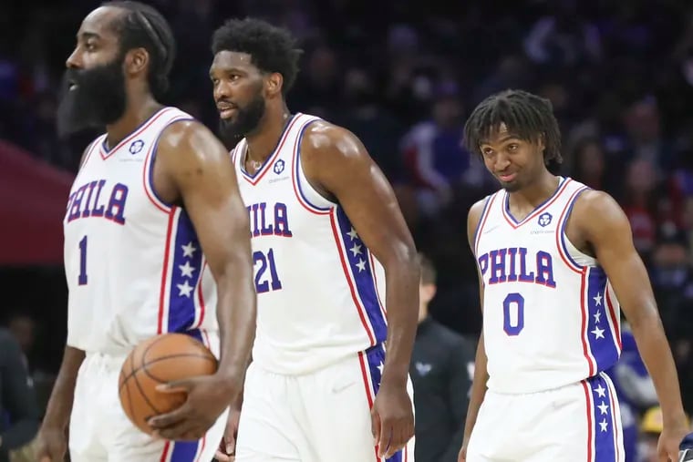 The Sixers' James Harden (1), Joel Embiid, and Tyrese Maxey (0) heading to the bench during a game against the Charlotte Hornets at the Wells Fargo Center on April 2.