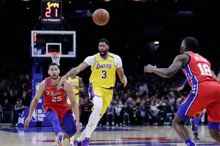 Sixers guard Ben Simmons tips the basketball towards teammate guard Shake Milton past Los Angeles Lakers forward Anthony Davis during the first quarter on Saturday.