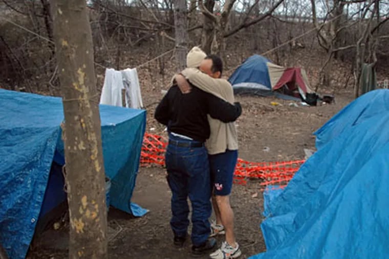 Neal Floyd hugs Lorenzo Jamaica, the unofficial "mayor" of tent city, as he leaves after being reunited with his family in the woods just outside downtown Camden in the pre-dawn Friday. (Tom Gralish / Staff Photographer)