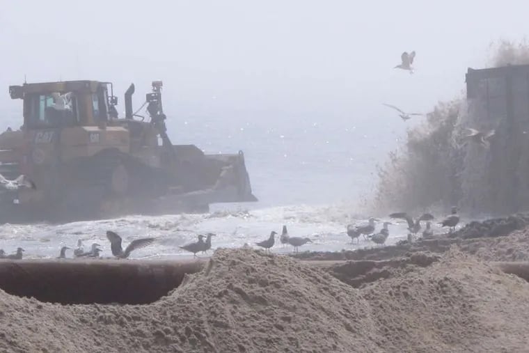 A bulldozer pushes newly pumped sand on a fog-shrouded beach in Ship Bottom, N.J. The Army Corps of Engineers started work this week on the $128 million project.