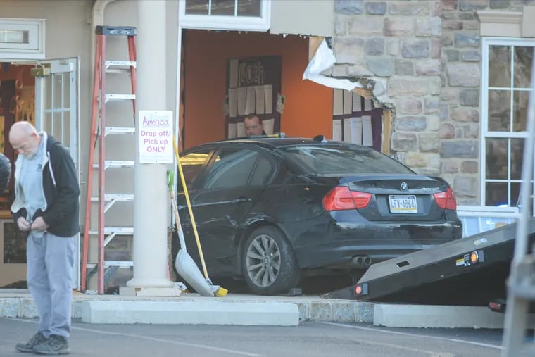 Police personnel remove the vehicle after a woman crashed it into the day care, injuring four children, one seriously.