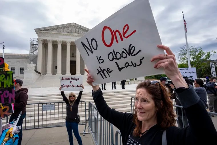 Diana Neary, of Minneapolis, joins other protesters demonstrating outside the U.S. Supreme Court on Thursday as the justices hear arguments over whether Donald Trump is immune from prosecution in a case charging him with plotting to overturn the results of the 2020 presidential election.