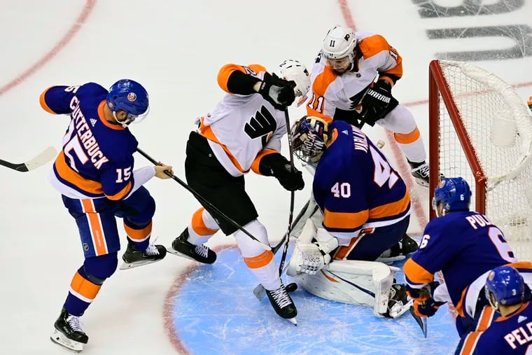 Flyers winger Michael Raffl (center) challenges Islanders goaltender Semyon Varlamov, who makes a pad save, in the second overtime period on Thursday.