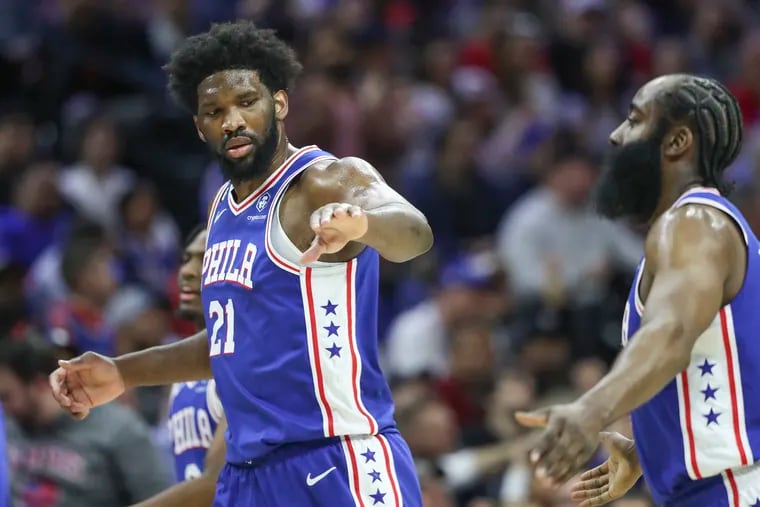 76ers' Joel Embiid high-fives James Harden during a game against the Mavs at the Wells Fargo Center in Philadelphia on March 29.
