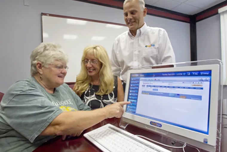 Fred Allegrezza and his wife, Nancy, watch as Carol Ann Davis (left) of North Wales operates the Telikin touch screen. (David M Warren / Staff Photographer)