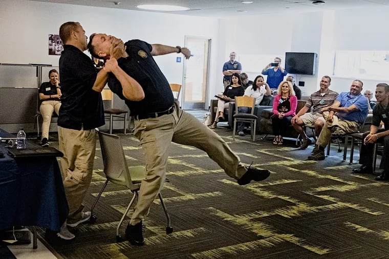In a program sponsored by Delaware County District Attorney's Office local teachers watch as Detectives Tony Ruggieri, left and Steve Banner demonstrate ways to fight off an attacker.