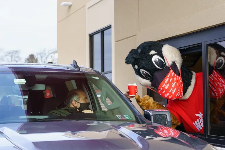 Wawa's mascot Wally Goose serves coffee to Jim Pilla on opening day of Wawa’s first drive-thru store in Westampton, N.J., in late 2020.